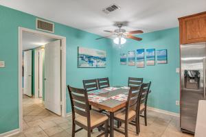 a dining room with a table and a ceiling fan at Pawsitively Paradise in Mustang Beach