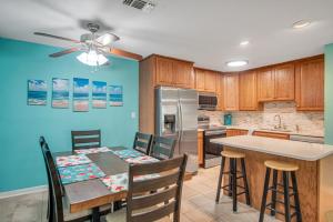 a kitchen with a dining table and a kitchen with blue walls at Pawsitively Paradise in Mustang Beach