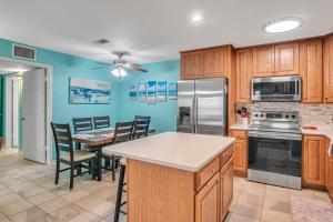 a kitchen with wooden cabinets and a table with chairs at Pawsitively Paradise in Mustang Beach