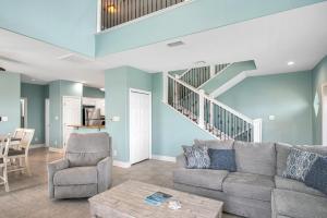a living room with a couch and a staircase at Sandbar in Port Aransas