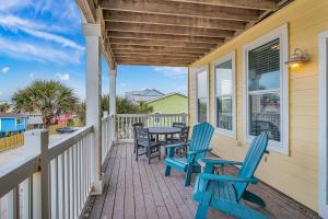 a porch with blue chairs and a table on it at Sandbar in Port Aransas +21 photos