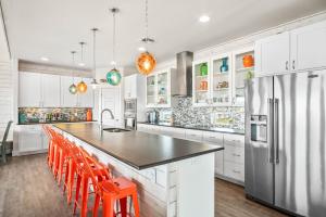 a kitchen with white cabinets and a stainless steel refrigerator at Beach-A-Holic in Padre Island +33 photos