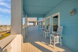 a blue house with chairs and tables on a porch at Ocean Spirit in Port Aransas