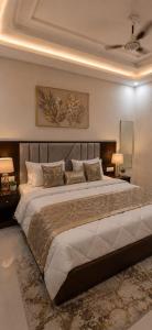a bedroom with a large bed and two lamps at Hotel Prime Grand Residency by Rd Hotels #Most Premium Hotel in vrindavan #Lift #Parking #Fully Ac in Chhatikara +12 photos
