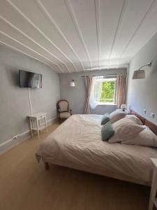 a bedroom with a large bed with a white ceiling at Auberge des Veillees in Blesle