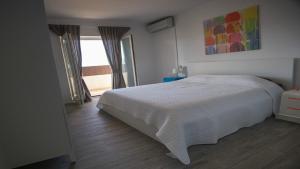 a bedroom with a white bed and a window at House Victoria in Lovište