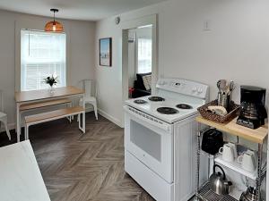 a kitchen with a white stove and a table with a dining room at Coral Cottage in Rockport