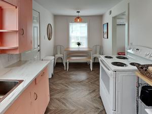 a kitchen with a stove and a dining table at Coral Cottage in Rockport