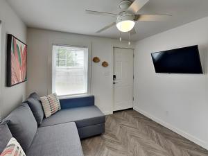 a living room with a couch and a flat screen tv at Coral Cottage in Rockport +7 photos