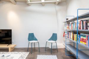 two chairs and a book shelf with books at Fiddlers Retreat in Santa Fe