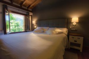 a bedroom with a large white bed with a window at Casa Rural Arregi in Oñate