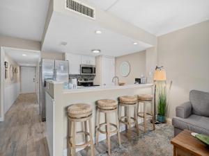 a kitchen and living room with a bar with stools at Laguna Reef #205 - La Las in Rockport