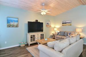a living room with a couch and a flat screen tv at Just Beachy in Port Aransas