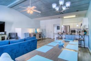a living room with a blue couch and a ceiling fan at Flip Flops & Pop Tops in Port Aransas