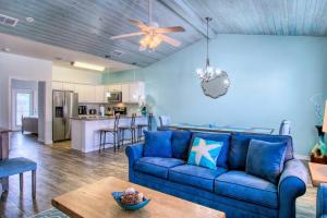 a living room with a blue couch and a kitchen at Flip Flops & Pop Tops in Port Aransas