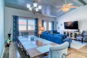 a living room with a table and a blue couch at Flip Flops & Pop Tops in Port Aransas