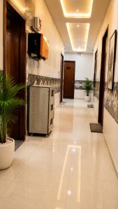 a hallway of a hospital with plants and a television at Hotel Prime Grand Residency by Rd Hotels #Most Premium Hotel in vrindavan #Lift #Parking #Fully Ac in Chhatikara