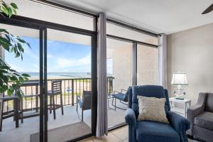 a living room with a blue chair and a balcony at Laguna Reef #212 - Shore 2 Please in Rockport