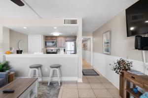 a kitchen and living room with a counter and stools at Laguna Reef #212 - Shore 2 Please in Rockport +29 photos