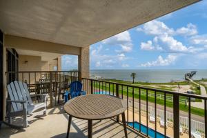 a balcony with a table and chairs and the ocean at Laguna Reef #308 - Beautiful Bay View in Rockport