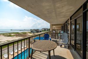 a balcony with a table and chairs and the beach at Laguna Reef #308 - Beautiful Bay View in Rockport +31 photos