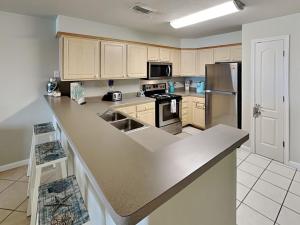 a kitchen with a counter top and a refrigerator at Port A Condo in Port Aransas