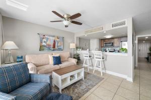 a living room with a couch and a ceiling fan at Laguna Reef #213 - Four Point Lighthouse in Rockport