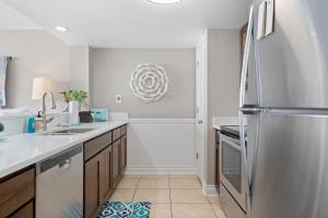 a kitchen with a refrigerator and a sink at Laguna Reef #213 - Four Point Lighthouse in Rockport +29 photos