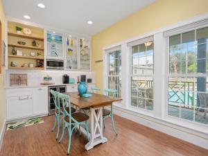 a kitchen with a table and chairs and windows at Magnolia Cottage in Rockport