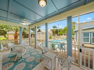 a screened porch with a table and chairs and a pool at Magnolia Cottage in Rockport