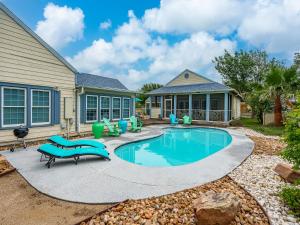 a swimming pool with blue chairs and a house at Magnolia Cottage in Rockport +12 photos