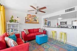 a living room with red couches and a kitchen at Laguna Reef #215 - Tequila Sunrise in Rockport