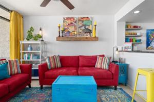 a living room with two red couches and a table at Laguna Reef #215 - Tequila Sunrise in Rockport