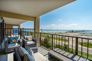 a balcony with chairs and a view of the beach at Laguna Reef #215 - Tequila Sunrise in Rockport