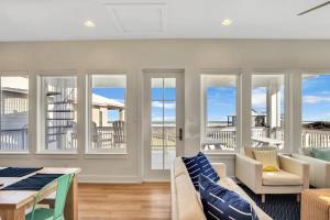 a living room with a couch and chairs and windows at The White House in Padre Island