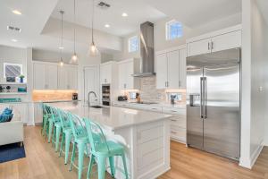 a kitchen with white cabinets and blue chairs at The White House in Padre Island +37 photos
