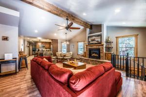 a living room with a red couch and a fireplace at The Great Escape in Ruidoso