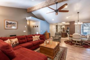 a living room with a red couch and a ceiling fan at The Great Escape in Ruidoso