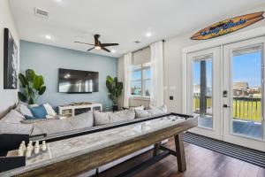 a living room with a large couch and a table at Sandy Cheeks Surfside in Surfside Beach