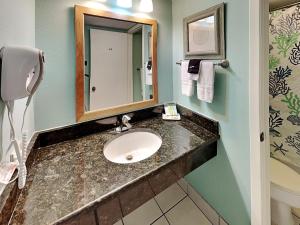 a bathroom with a sink and a mirror at Laguna Reef #121 - Gone Coastal in Rockport
