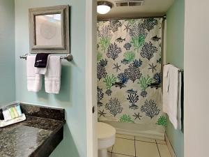a bathroom with a toilet and a shower curtain at Laguna Reef #121 - Gone Coastal in Rockport