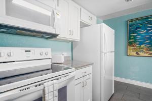 a kitchen with white appliances and blue walls at Laguna Reef #211 - Rod and Reel in Rockport