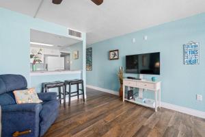 a living room with blue walls and a blue couch at Laguna Reef #211 - Rod and Reel in Rockport