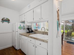 a white kitchen with a sink and a refrigerator at Beautiful Bay View Condo in Rockport