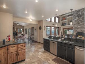 a large kitchen with black counter tops and a fireplace at Avalon in Ruidoso +36 photos