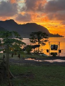 a sunset over a body of water with a boat at Maroe Bay Lodge in HUH