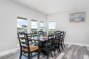 a dining room with a table and chairs and windows at Edgewater Escape in Rockport