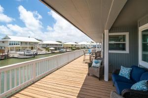 a porch with a blue couch and chairs on a balcony at Edgewater Escape in Rockport