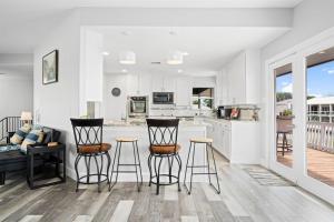 a kitchen and living room with bar stools and a couch at Edgewater Escape in Rockport +30 photos