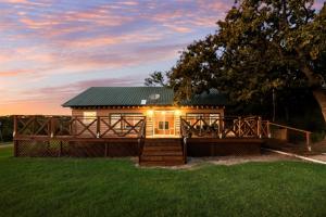 a small house with a deck in a field at Willow Heaven - Lakefront Cabin Escape in Madill